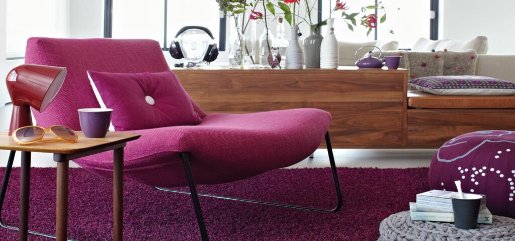Ein Wohnzimmer mit einem lila Stuhl und einem Couchtisch. Raumausstattung Merget | Goethestraße 43 | 63814 Mainaschaff