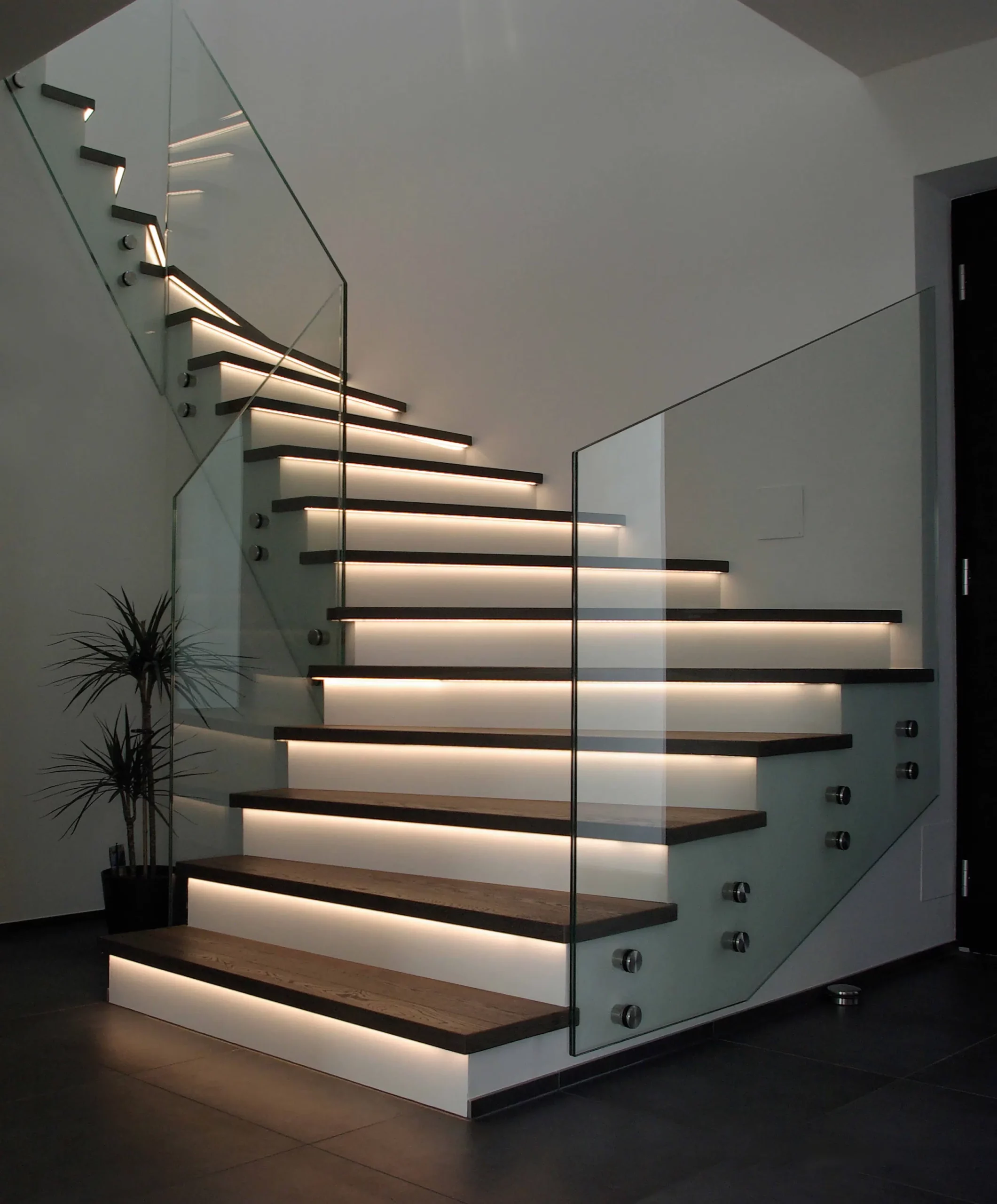 Eine moderne Treppe mit Glasgeländer und Beleuchtung. Raumausstattung Merget | Goethestraße 43 | 63814 Mainaschaff