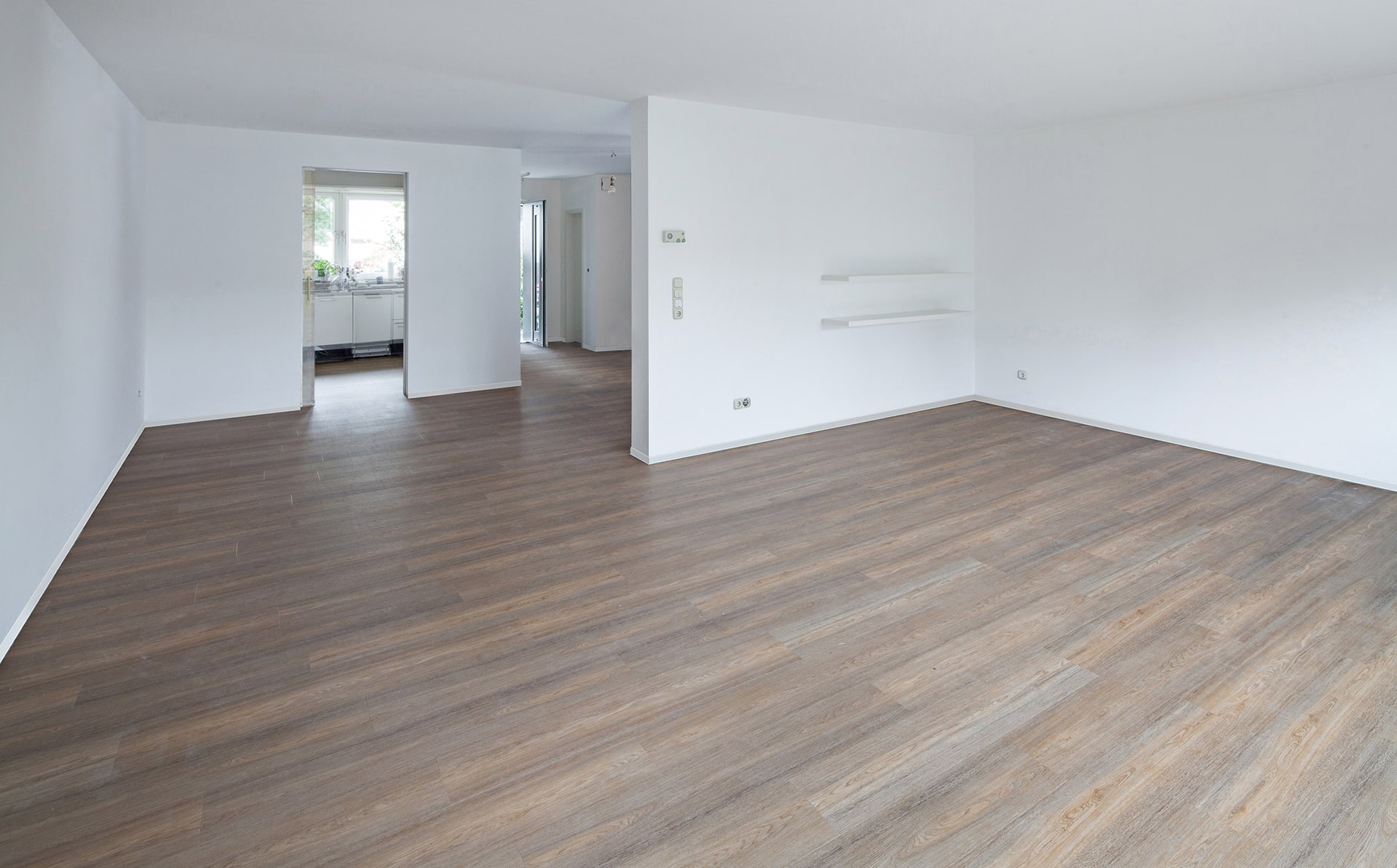 Ein leerer Raum mit Holzböden und weißen Wänden. Raumausstattung Merget | Goethestraße 43 | 63814 Mainaschaff