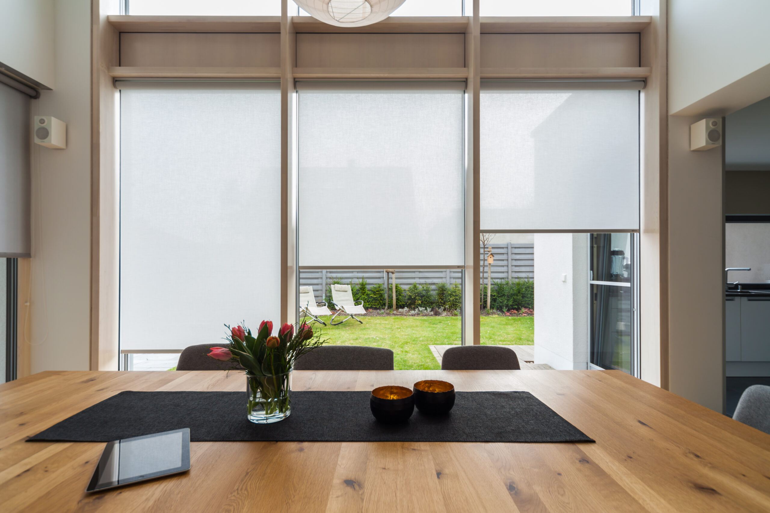 Modernes Esszimmer mit großem Fenster zum Garten, angereichert mit zahlreichen Referenzen. Raumausstattung Merget | Goethestraße 43 | 63814 Mainaschaff