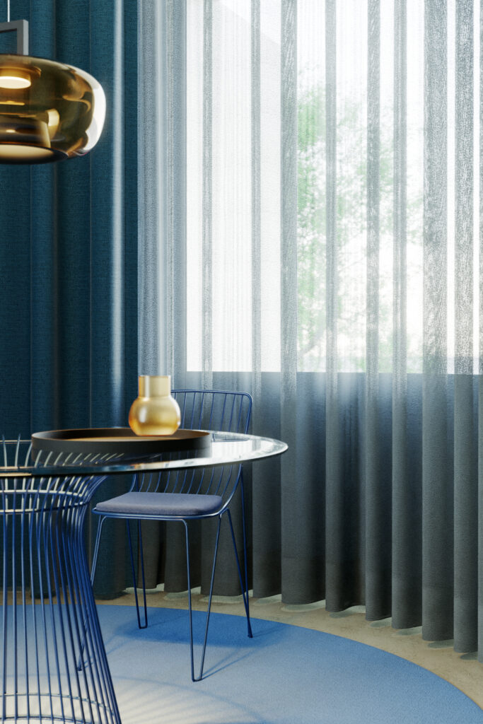 Moderner, minimalistischer Essbereich mit blauen Drahtstühlen, einem runden Tisch und kontrastierender Gardinenwäsche vor einem sonnendurchfluteten Fenster. Raumausstattung Merget | Goethestraße 43 | 63814 Mainaschaff