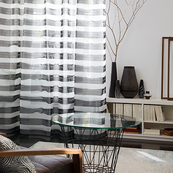 Modernes Wohnzimmer mit Gardinen, Couchtisch mit Glasplatte und minimalistischem Dekor. Raumausstattung Merget | Goethestraße 43 | 63814 Mainaschaff